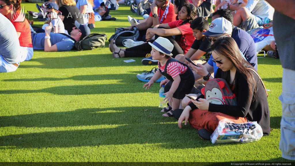 Group of people sitting on artificial grass