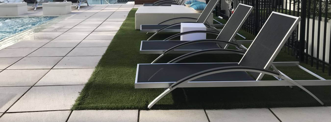 Commercial pool area with artificial grass landscaping