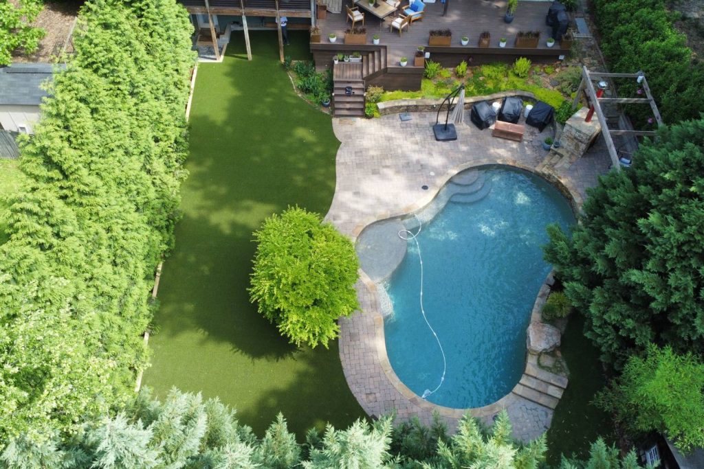 Artificial grass backyard with pool drone shot