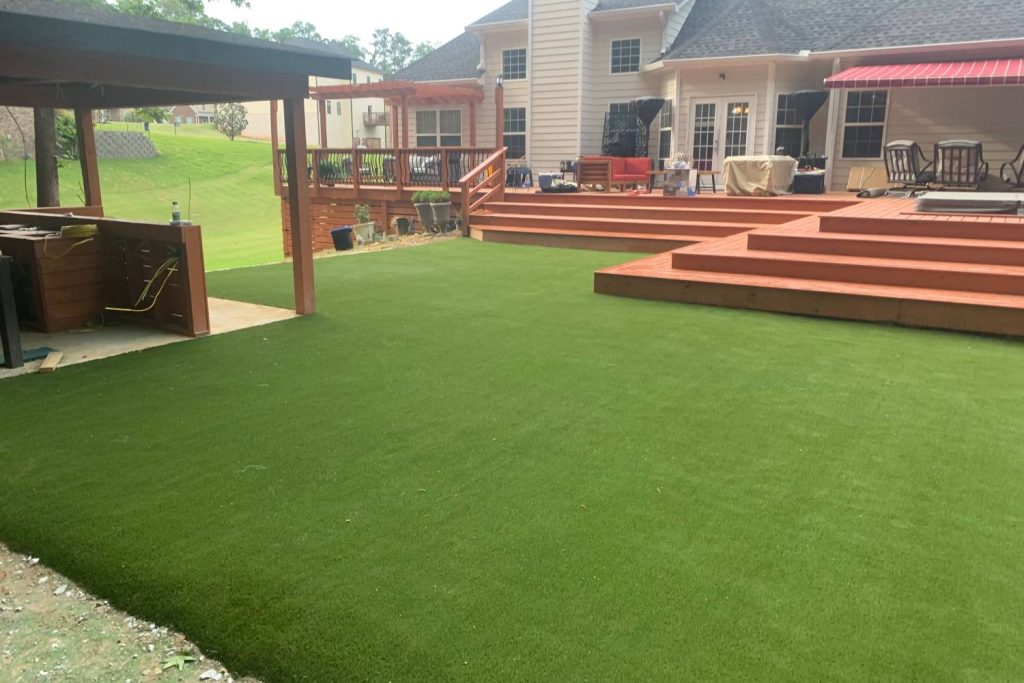 Wooden patio with artificial grass backyard