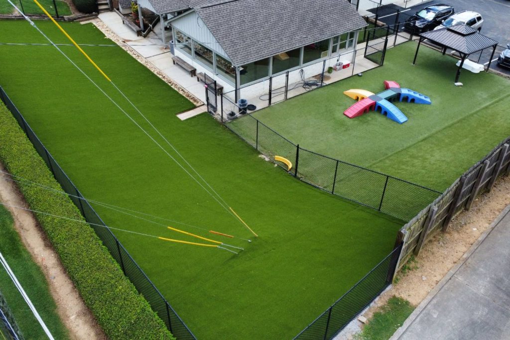 Commercial artificial grass area with play equipment and powerlines